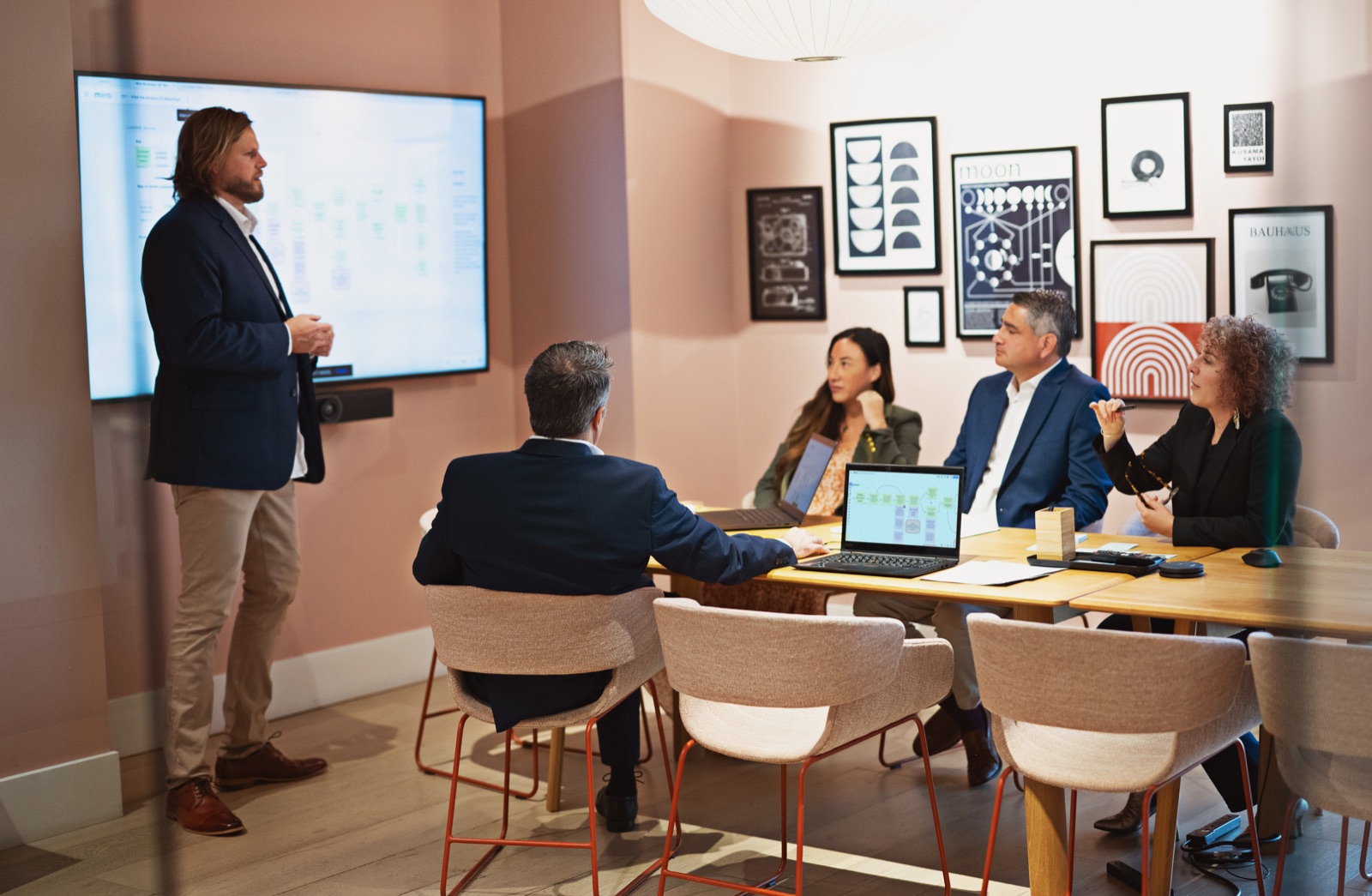 Richard Kimball presenting a product workflow diagram to a team in a conference room