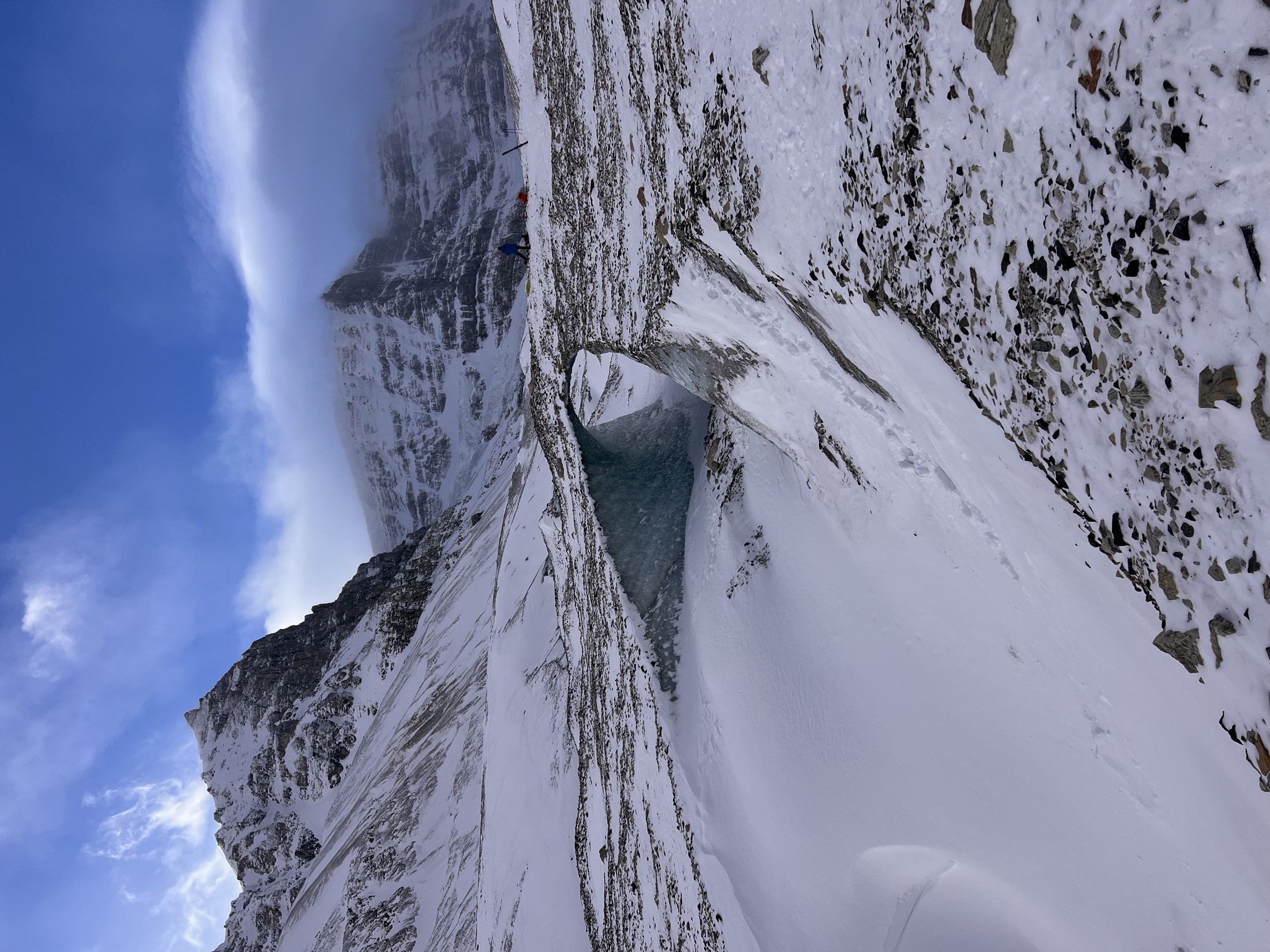 Looking out through a glacier ice cave toward snow-covered mountains, Banff