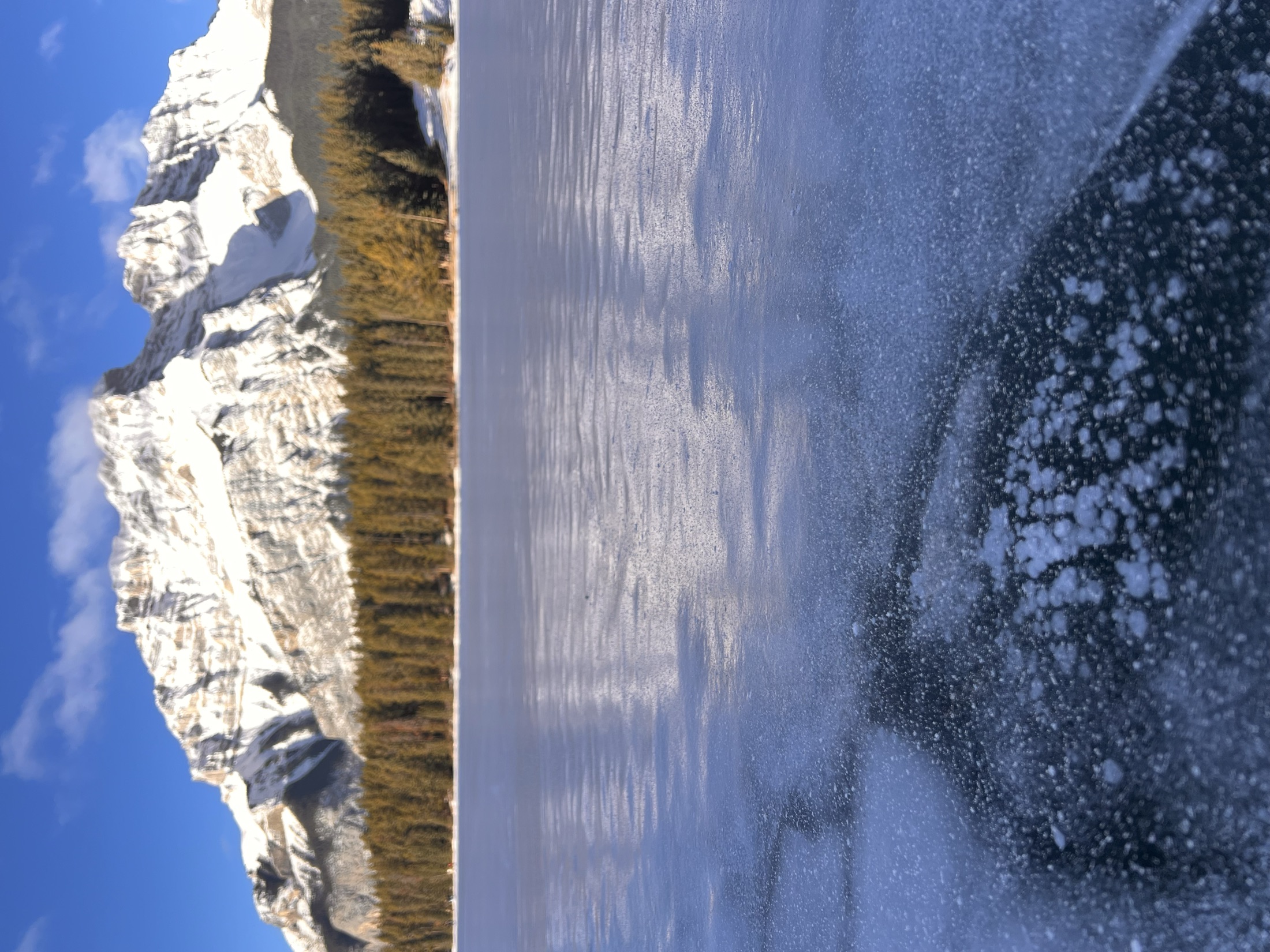 Ice bubbles trapped in a frozen lake with a mountain backdrop, Banff
