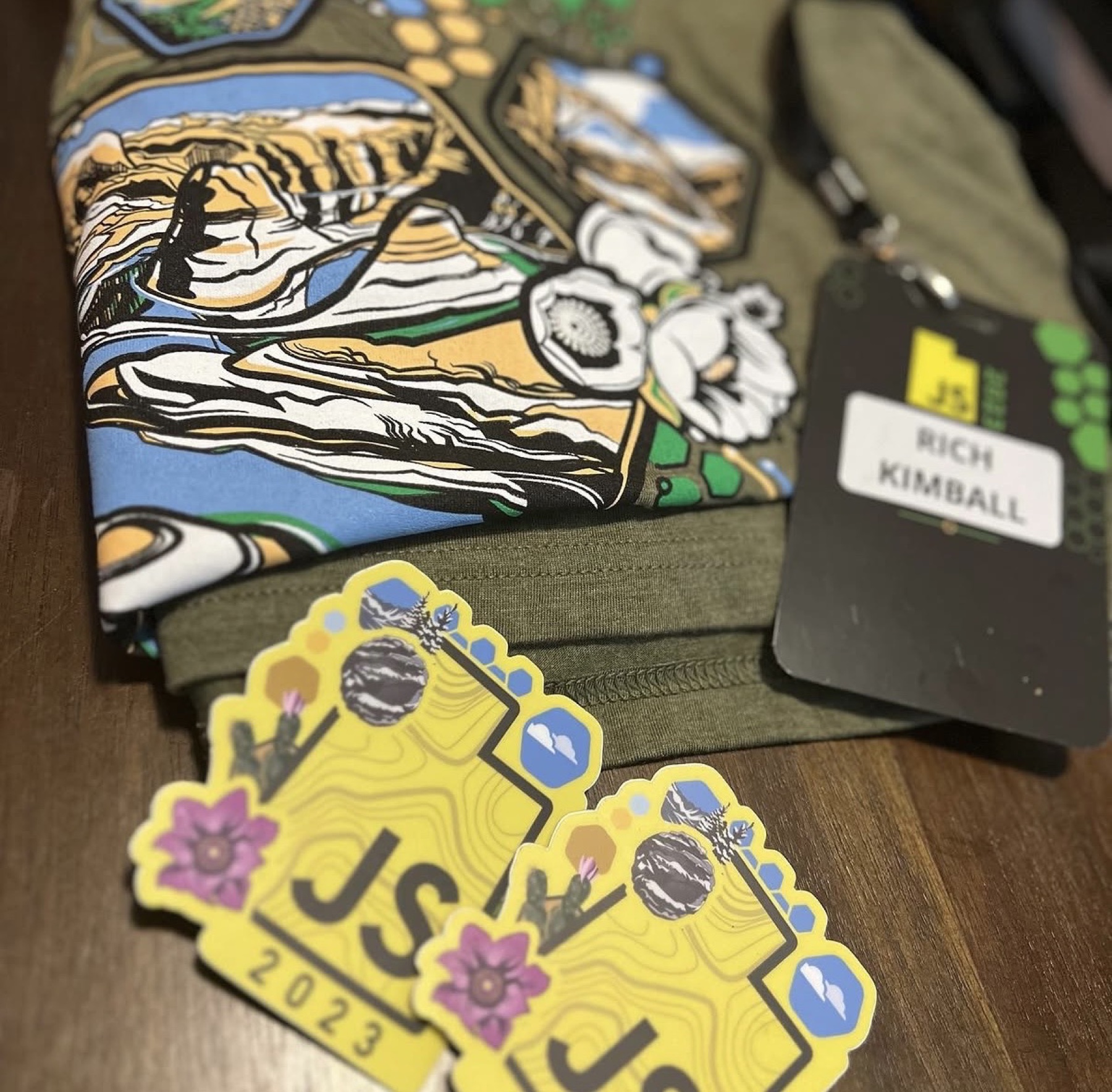 UtahJS 2023 shirt, stickers, and lanyard flat lay